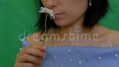 一个美丽<strong>迷人</strong>的女孩吸入了一朵花的<strong>芬芳</strong>。 白色的伪装。